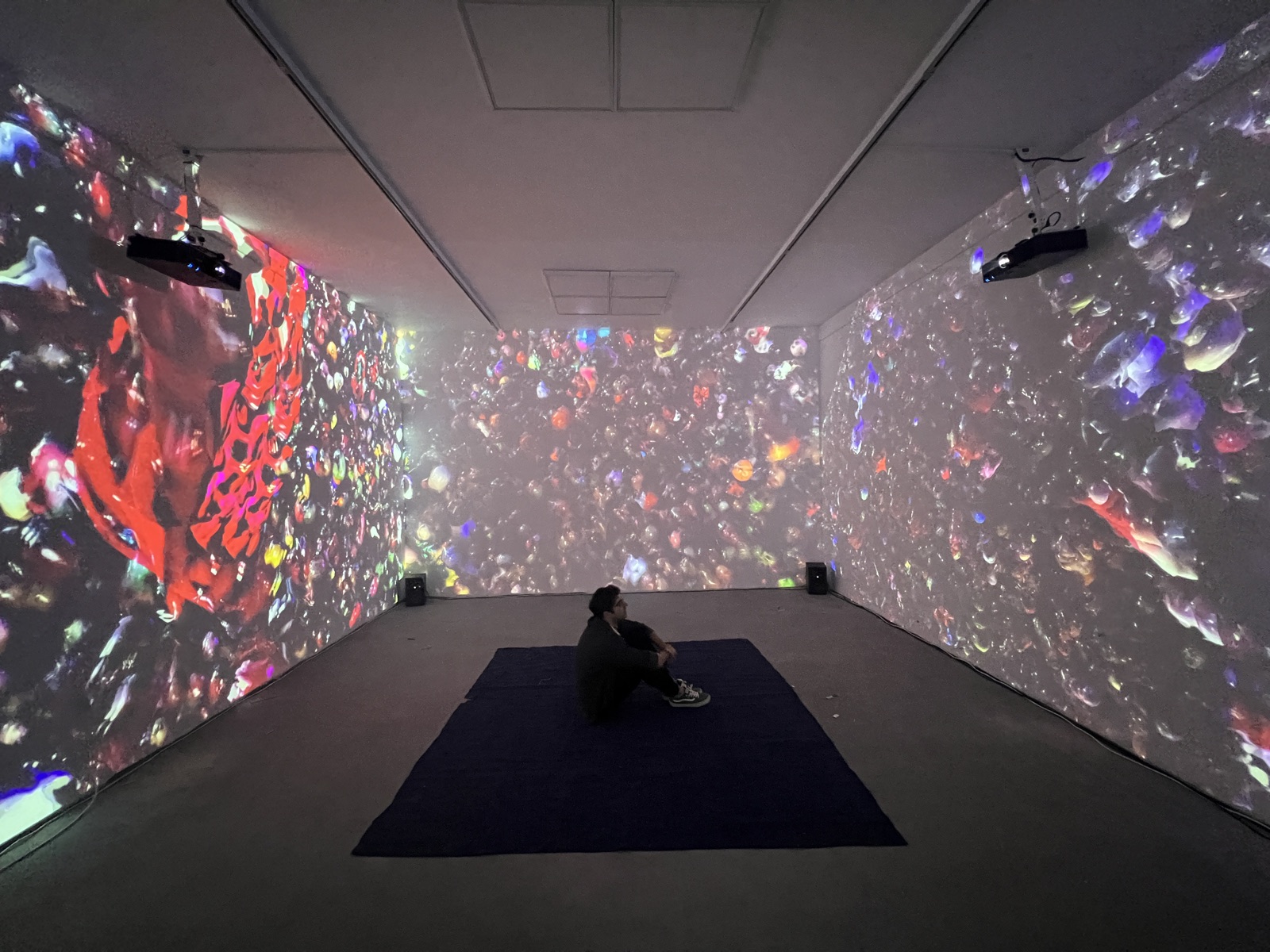 Three-wall projection surrounding a seated viewer, Kosovo 2023